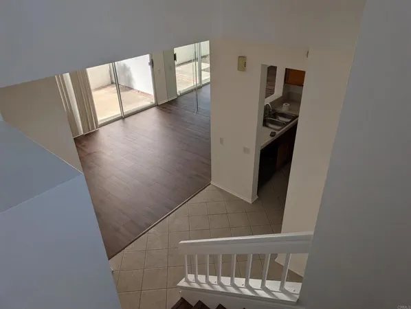 a view of a hallway with wooden floor and stairs