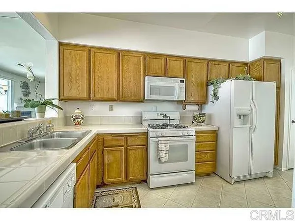 a kitchen with a sink a refrigerator and cabinets