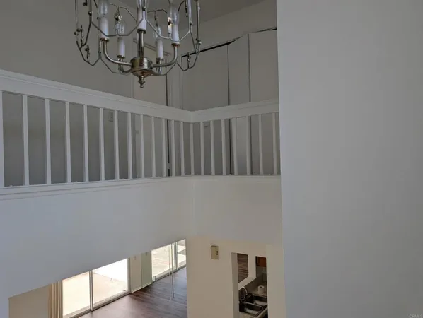 a view of staircase with railing and chandelier