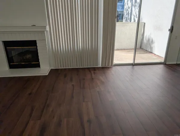 a view of a livingroom with wooden floor and fireplace