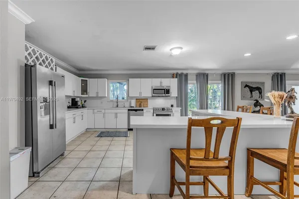a kitchen with stainless steel appliances a refrigerator sink and cabinets