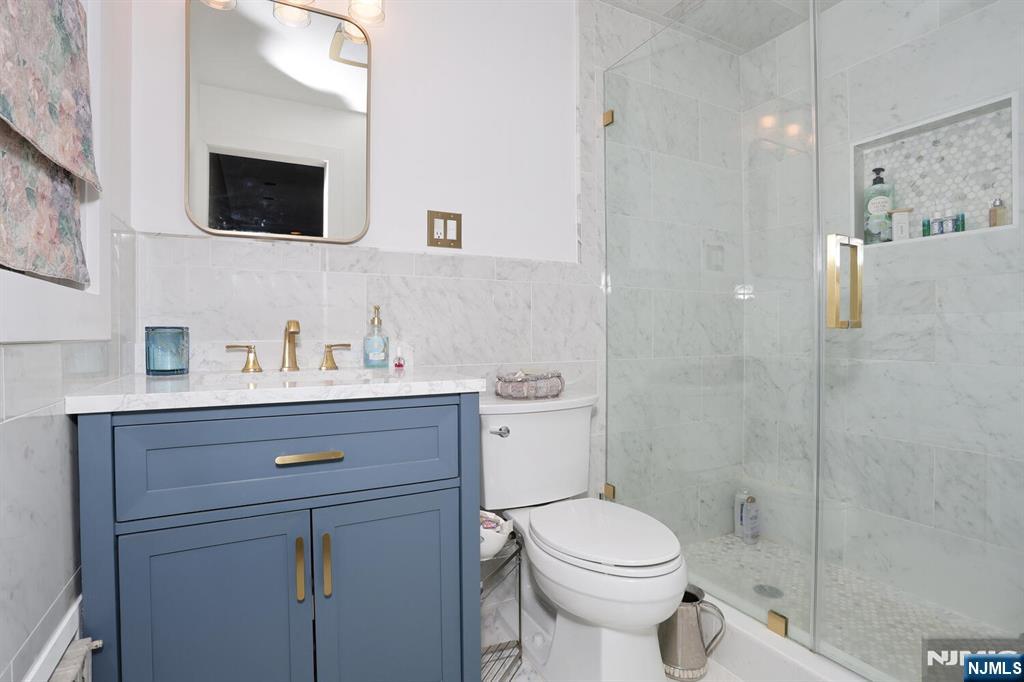 28 Bear Mountain Road Ringwood, NJ 07456 - Photo 30 of 50 a bathroom with a sink a mirror a toilet and shower