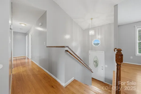 a view of hallway with stairs and wooden floor