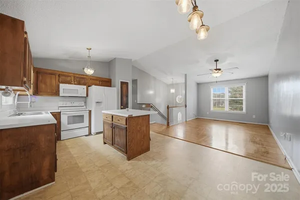 a view of living room kitchen with stainless steel appliances cabinets and flat screen tv