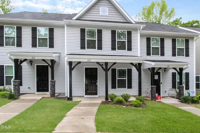 front view of a brick house with a yard