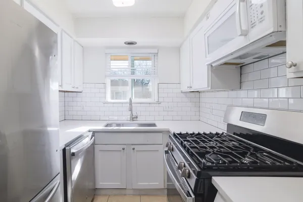 a kitchen with granite countertop a sink stove and cabinets