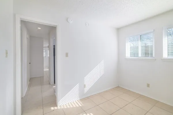 a view of an empty room with window and stairs