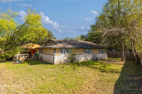 a front view of a house with yard and trees