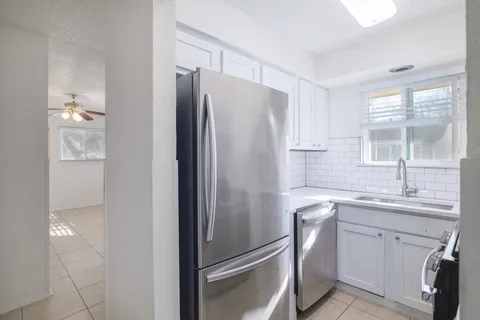 a kitchen with a refrigerator sink and cabinets