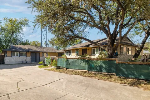 a view of a house with a large tree and a yard