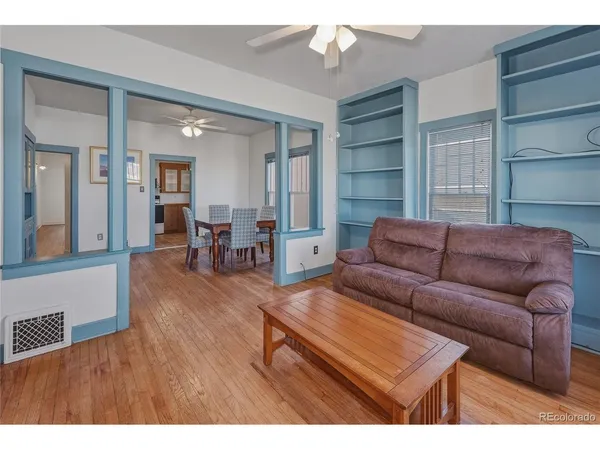 a living room with furniture and a wooden floor