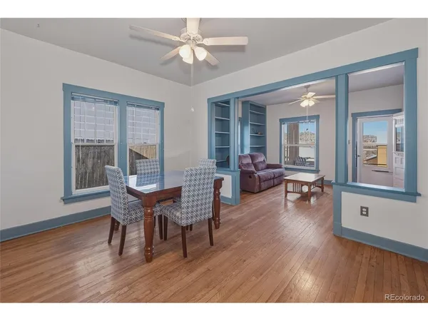 a dining room with furniture a chandelier and wooden floor