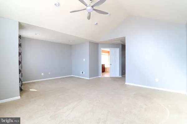 a view of an empty room with a ceiling fan
