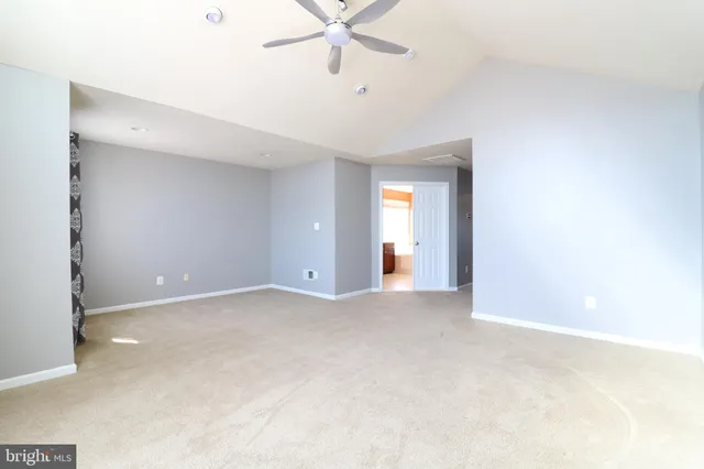 a view of an empty room with a ceiling fan