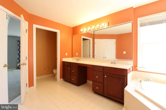a spacious bathroom with a double vanity sink and a mirror