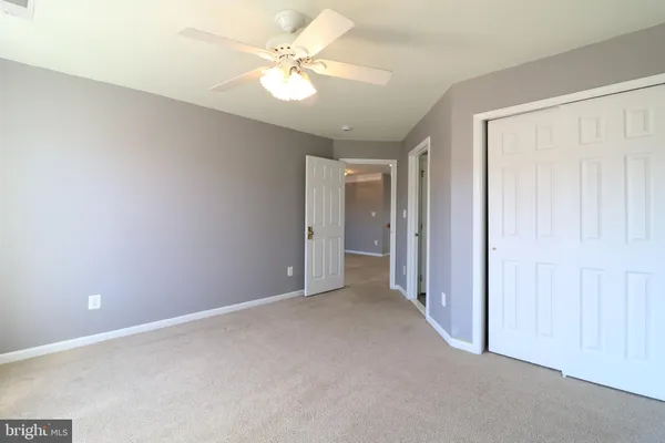 an empty room with a ceiling fan and a window