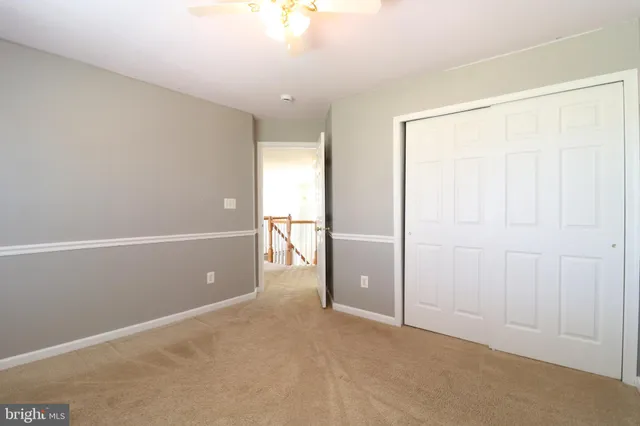 en empty room with windows and fan