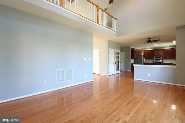 a view of a kitchen with kitchen island wooden floor and stainless steel appliances