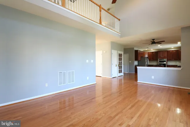 a view of a kitchen with kitchen island wooden floor and stainless steel appliances