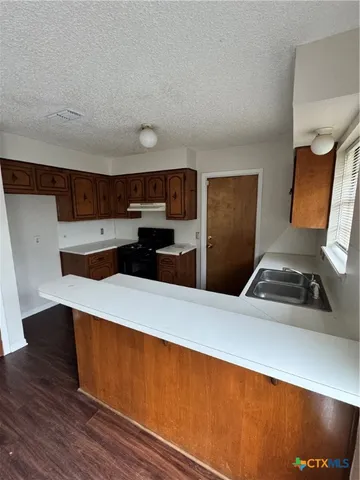 a kitchen with stainless steel appliances a refrigerator and a stove top oven