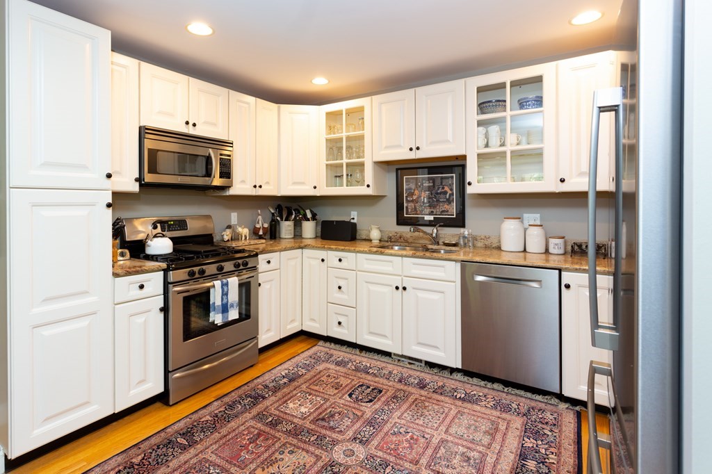 6 North Street Mashpee, MA 02649 - Photo 6 of 22 a kitchen with stainless steel appliances granite countertop a refrigerator and a stove top oven