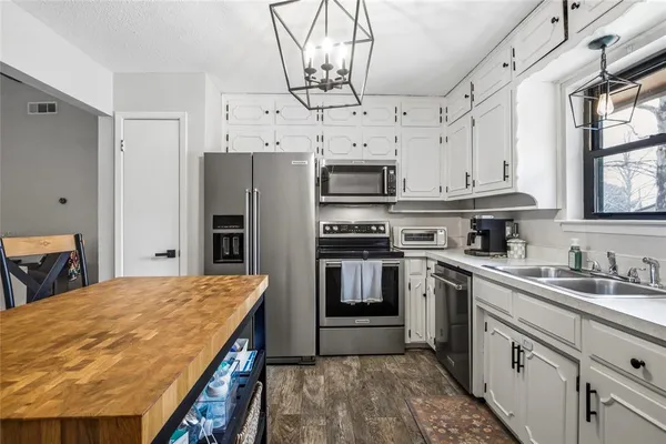 a kitchen with stainless steel appliances a stove refrigerator sink and microwave