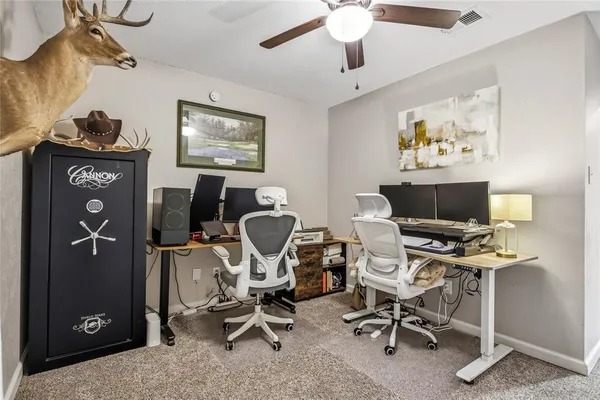 a view of a workspace with furniture and a window