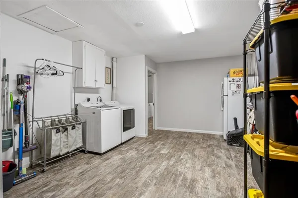 a view of a kitchen with fridge and wooden floor