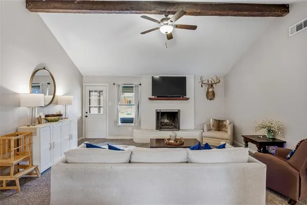 a living room with furniture a fireplace and a flat screen tv