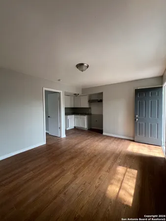 a view of empty room with a kitchen