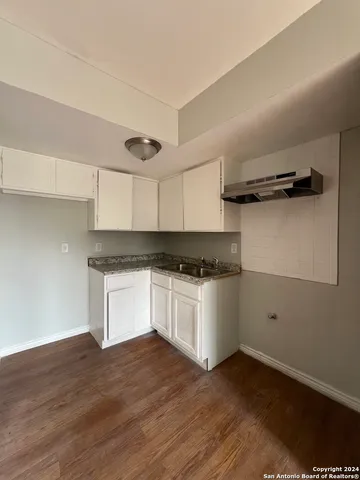 a kitchen with granite countertop white cabinets and black appliances