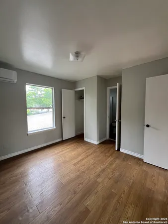 an empty room with windows and closet