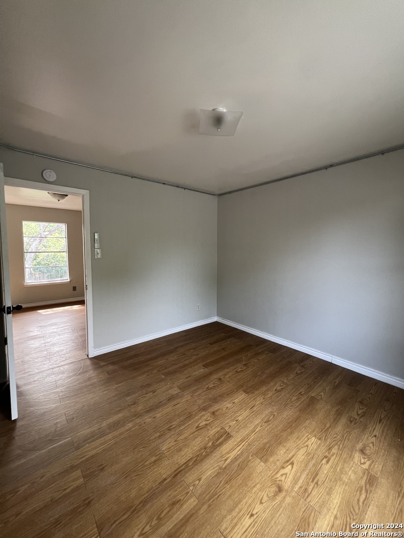 1723 West Mayfield Boulevard, Unit 5 San Antonio, TX 78211 - Photo 10 of 13 a view of empty room with wooden floor and fan