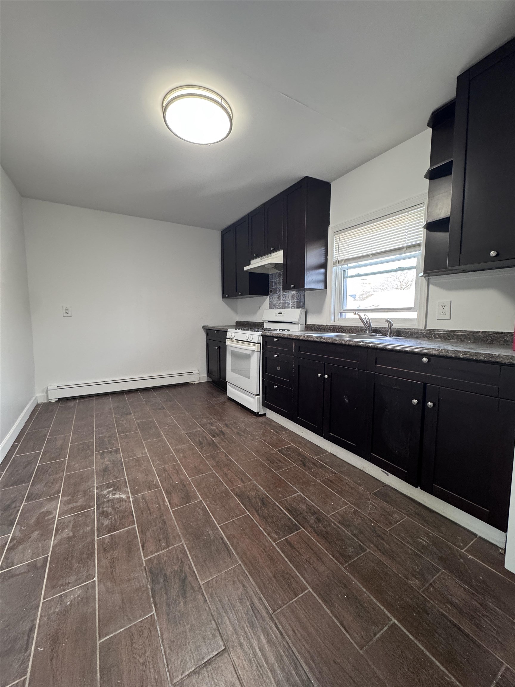 1624 Teaneck Road, Unit 2 Teaneck, NJ 07666 - Photo 2 of 7 a kitchen with granite countertop a stove a sink and a microwave