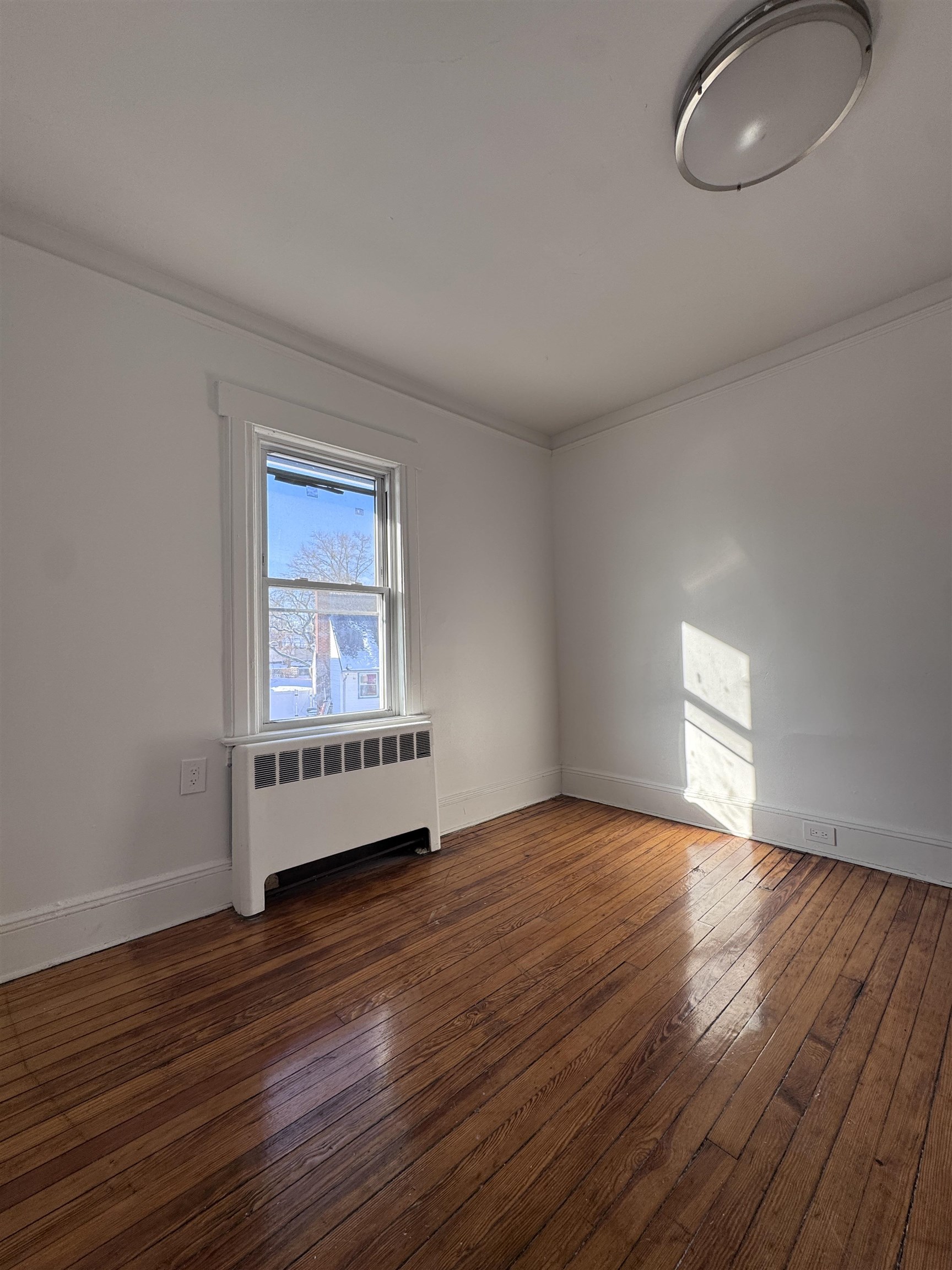 1624 Teaneck Road, Unit 2 Teaneck, NJ 07666 - Photo 6 of 7 an empty room with wooden floor and windows
