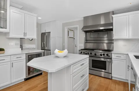 a kitchen with stainless steel appliances a white stove top oven a sink dishwasher and cabinets with wooden floor