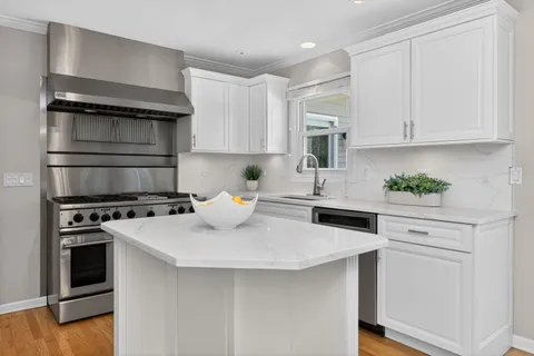 a kitchen with stainless steel appliances granite countertop a stove a sink and a microwave