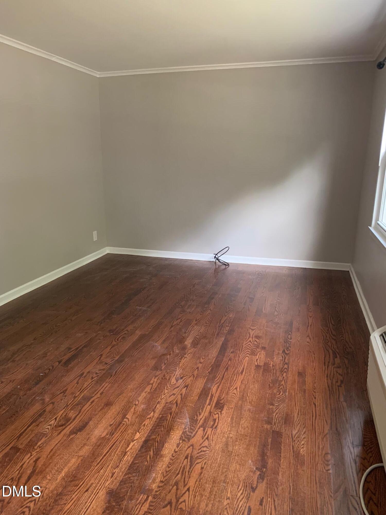 629 Daniels Street, Unit B Raleigh, NC 27605 - Photo 5 of 8 a view of an empty room with wooden floor and a window