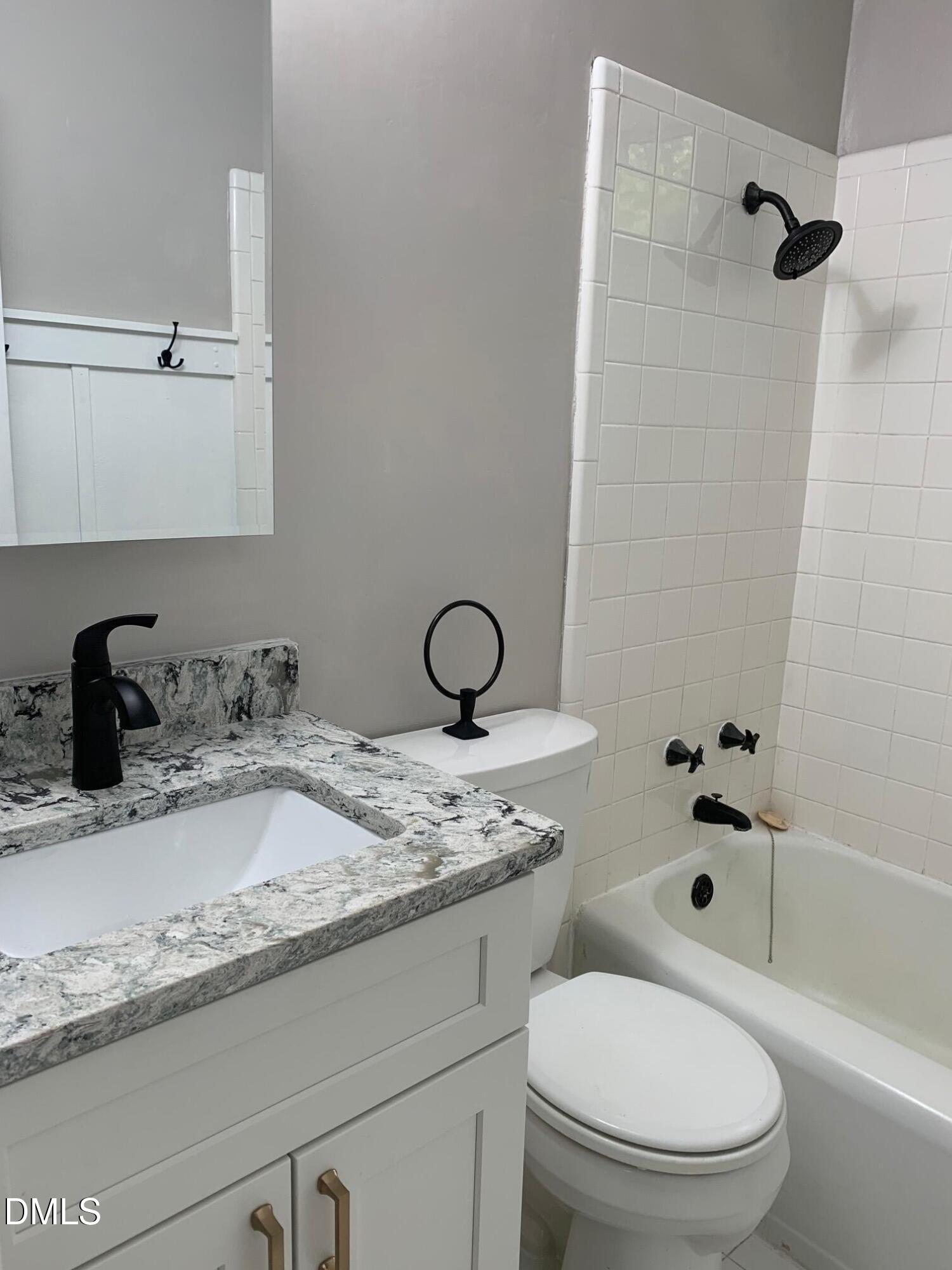 629 Daniels Street, Unit B Raleigh, NC 27605 - Photo 7 of 8 a bathroom with a granite countertop sink toilet and shower