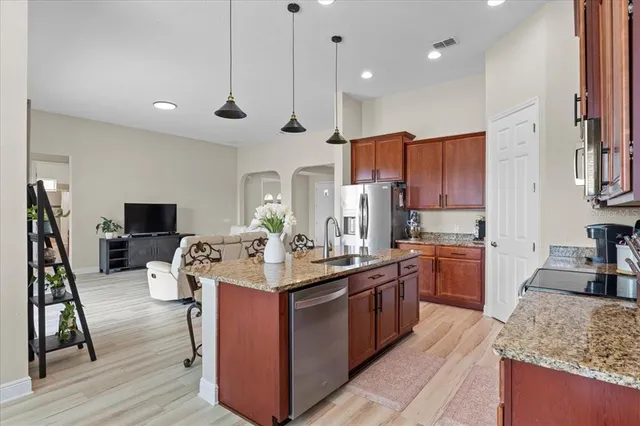 a kitchen with stainless steel appliances granite countertop a sink stove and refrigerator