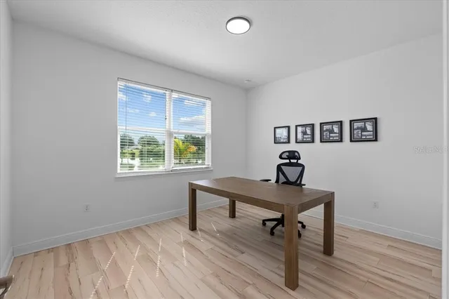 a view of a workspace with furniture and a window