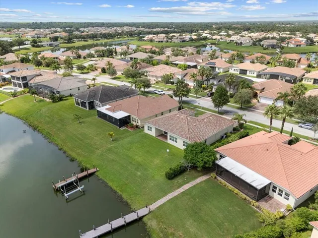 an aerial view of residential houses with outdoor space and trees