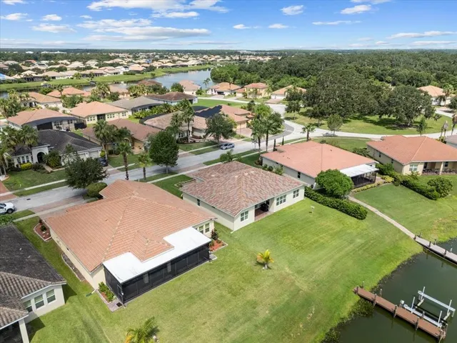 an aerial view of residential houses with outdoor space and trees