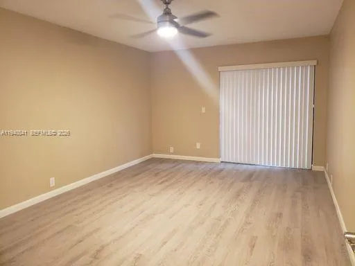 a view of a room with wooden floor and white walls