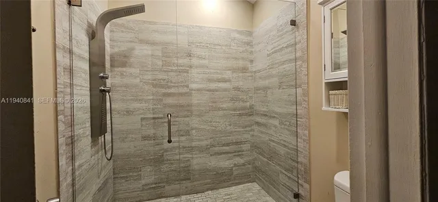 a bathroom with a shower a toilet and sink