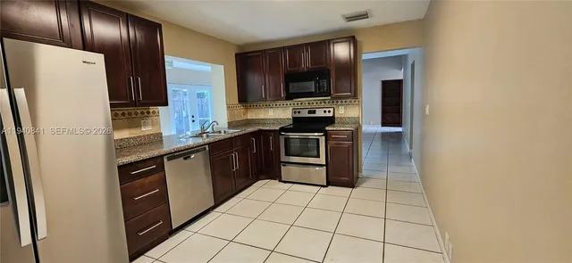 a kitchen with stainless steel appliances a refrigerator stove microwave and sink