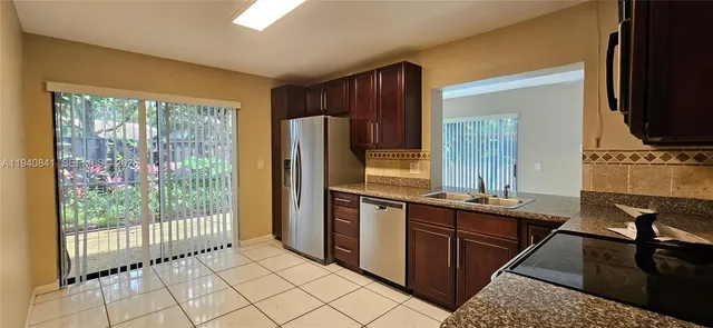 a kitchen with stainless steel appliances granite countertop a refrigerator and a stove top oven