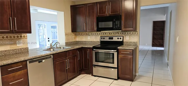 a kitchen with stainless steel appliances granite countertop a sink stove and microwave