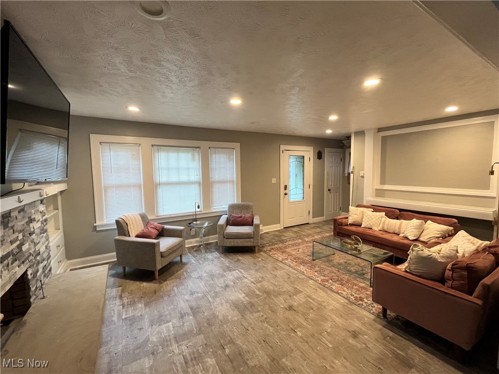 1048 Pembrook Road Cleveland, OH 44121 - Photo 5 of 26 Living room featuring wood-type flooring, a textured ceiling, and a fireplace