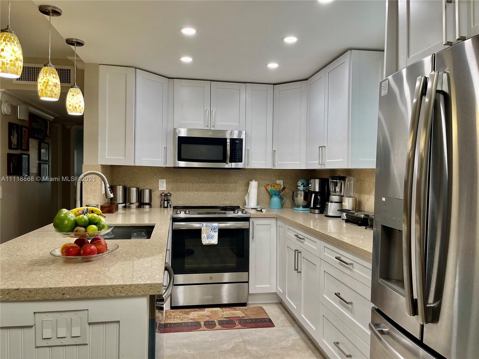 Kings Point Piedmont Delray Beach, FL 33484 - Photo 14 of 22 a kitchen with granite countertop a refrigerator stove and white cabinets